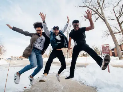three students jumping